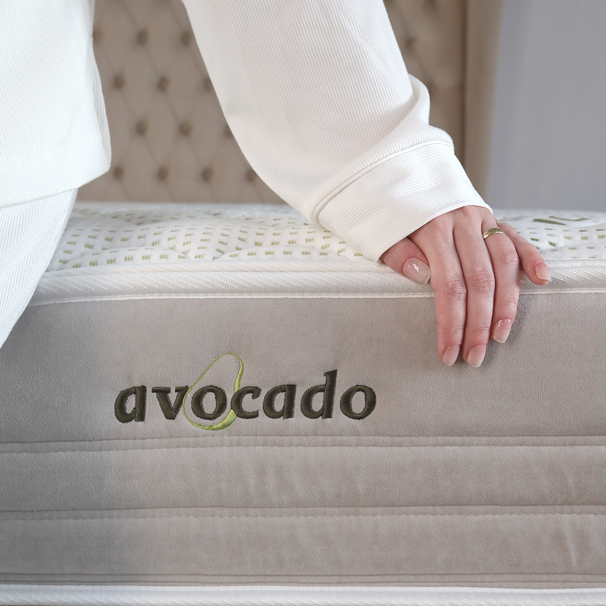 Detail potahu AVOCADO matrace COCONUT PREMIUM T4 s rukou na jeho okraji.