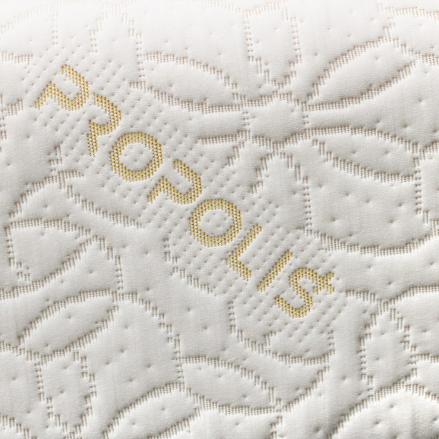 Detail bílého prošívaného potahu s nápisem PROPOLIS na matraci HONEY DREAM.