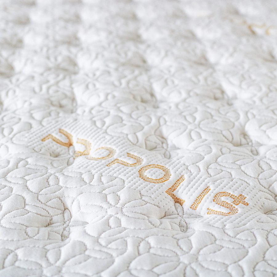 Matrace PROPOLIS COMFORT, detail bílého prošívaného potahu s nápisem PROPOLIS.